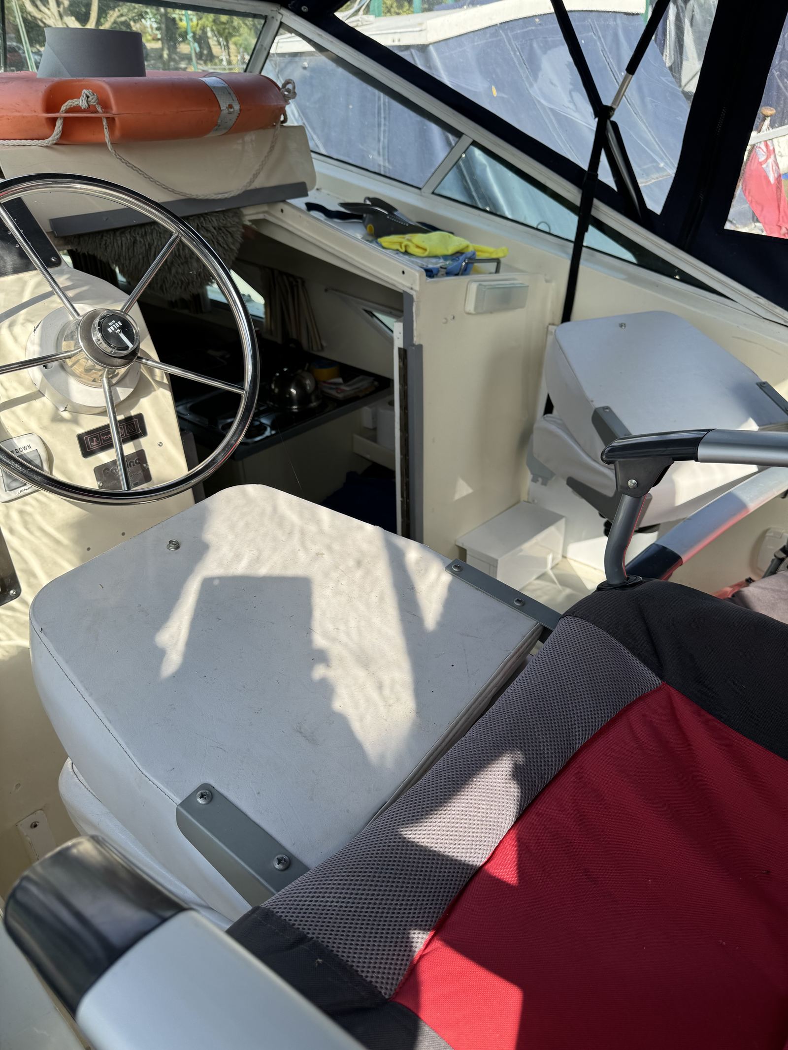 The helm of “Sweet Revenge”: stainless wheel, instruments, and the galley through to the cabin.