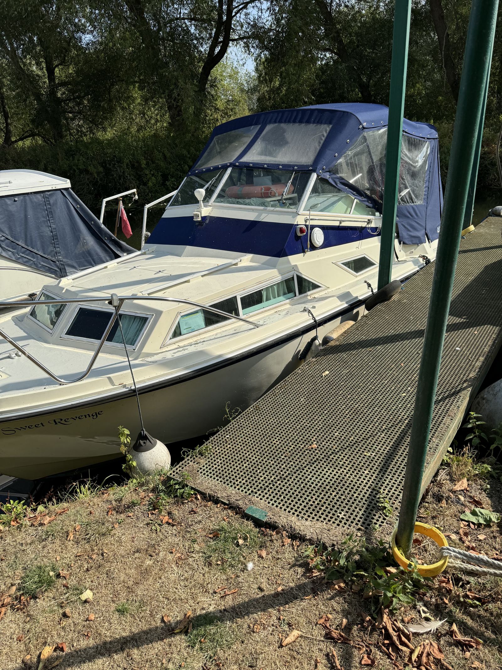 “Sweet Revenge” alongside the pontoon at Strensham Mill, navy canopy up, willows behind.