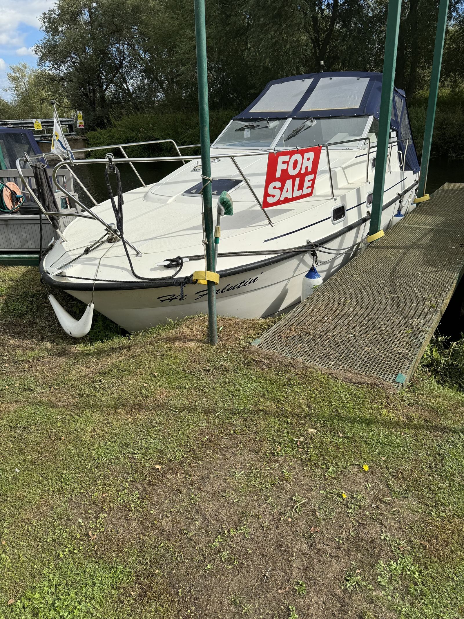 Hi-Falutin, a Shadow 26 foot cruiser, moored at Strensham Mill with a for sale sign on the guard rail.